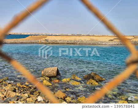 Rocky Seashore Viewed Through Blurred Fence Rocky Seashore Viewed Through Blurred Fence 139578841