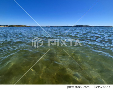 Clear blue sea with distant coastline and horizon Clear blue sea with distant coastline and horizon 139578863