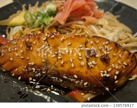 Glazed salmon steak with sesame over noodles Glazed salmon steak with sesame over noodles 139578917
