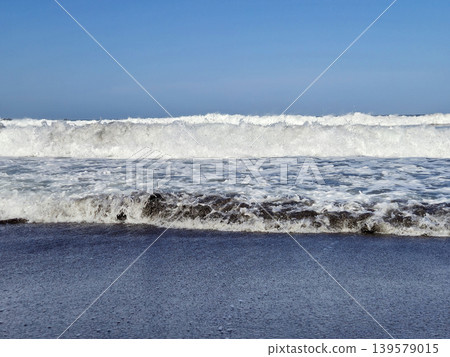 Ocean Waves Breaking on Sandy Beach 139579015