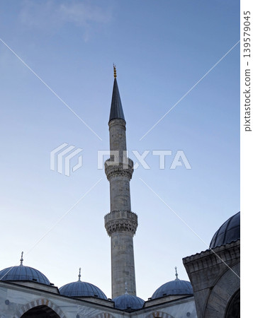 Tall mosque minaret against clear blue sky Tall mosque minaret against clear blue sky 139579045