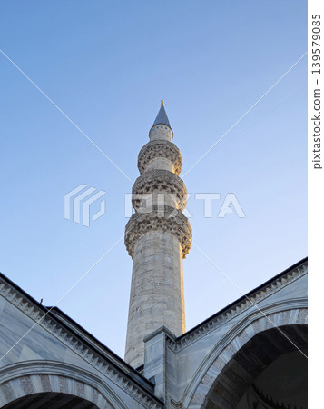 Tall mosque minaret against clear blue sky 139579085
