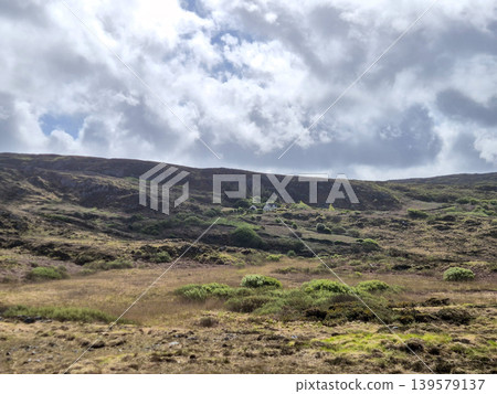 Remote hillside landscape beneath dramatic cloudy sky Remote hillside landscape beneath dramatic cloudy sky 139579137