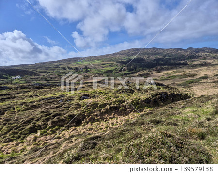 Rugged hillside landscape under dramatic cloudy sky Rugged hillside landscape under dramatic cloudy sky 139579138