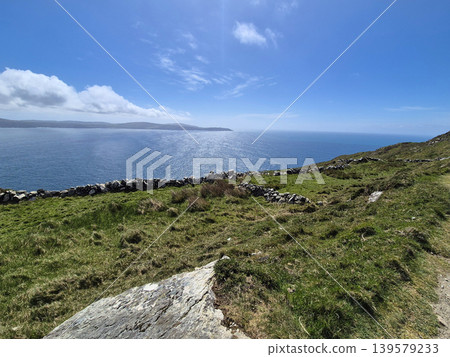 Coastal cliff overlooking calm blue sea Coastal cliff overlooking calm blue sea 139579233