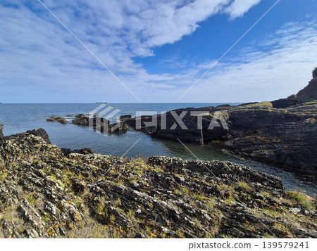 Rocky Seashore Under Blue Cloudy Sky 139579241