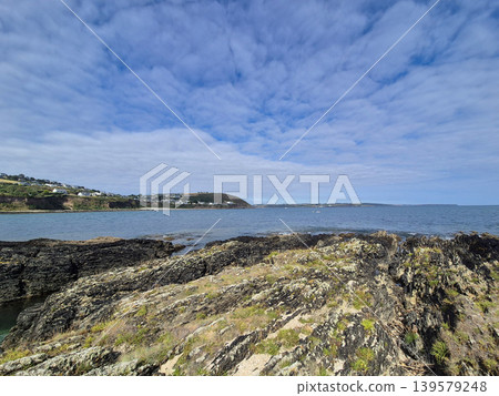 Rocky coastline with calm sea and cloudy sky 139579248
