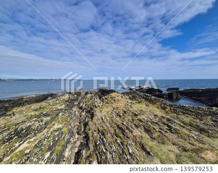 Rocky coastline beneath dramatic cloudy sky Rocky coastline beneath dramatic cloudy sky 139579253