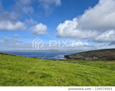 Green coastal landscape under blue cloudy sky Green coastal landscape under blue cloudy sky 139579303