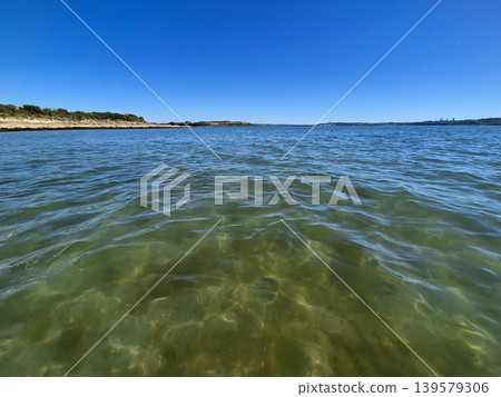 Calm coastal water under clear blue sky Calm coastal water under clear blue sky 139579306