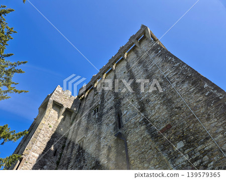 Ancient stone castle tower against blue sky Ancient stone castle tower against blue sky 139579365