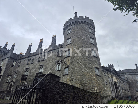 Historic stone castle with round tower and cloudy sky Historic stone castle with round tower and cloudy sky 139579366