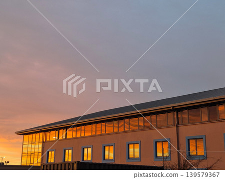 Modern building reflecting golden sunset light Modern building reflecting golden sunset light 139579367