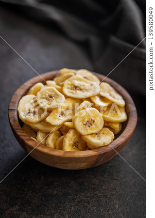 Crispy Banana Chips in Wooden Bowl - Healthy Dried Fruit Snack for Home and Travel Crispy Banana Chips in Wooden Bowl - Healthy Dried Fruit Snack for Home and Travel 139580049