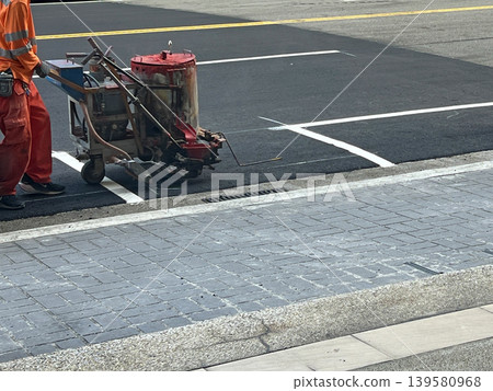 Workers laying asphalt on the road. Workers laying asphalt on the road. 139580968