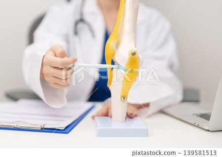 Doctor with Human Knee joint anatomy model. Osteoarthritis, Patellofemoral Pain Syndrome, Patellar Tendinitis, ACL, Anterior Cruciate Ligament, PCL, Posterior, MCL, Medial Collateral, LCL and Lateral Doctor with Human Knee joint anatomy model. Osteoarthritis, Patellofemoral Pain Syndrome, Patellar Tendinitis, ACL, Anterior Cruciate Ligament, PCL, Posterior, MCL, Medial Collateral, LCL and Lateral 139581513