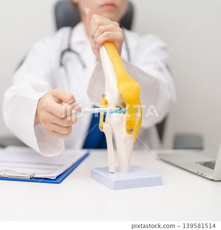 Doctor with Human Knee joint anatomy model. Osteoarthritis, Patellofemoral Pain Syndrome, Patellar Tendinitis, ACL, Anterior Cruciate Ligament, PCL, Posterior, MCL, Medial Collateral, LCL and Lateral Doctor with Human Knee joint anatomy model. Osteoarthritis, Patellofemoral Pain Syndrome, Patellar Tendinitis, ACL, Anterior Cruciate Ligament, PCL, Posterior, MCL, Medial Collateral, LCL and Lateral 139581514