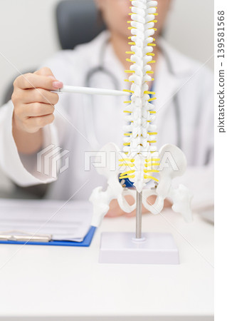 Doctor with human Spine anatomy model. Spinal Cord Disorder and disease, Back pain, Lumbar, Sacral pelvis, Cervical neck, Thoracic, Coccyx, Orthopedist, chiropractic, Office Syndrome and health Doctor with human Spine anatomy model. Spinal Cord Disorder and disease, Back pain, Lumbar, Sacral pelvis, Cervical neck, Thoracic, Coccyx, Orthopedist, chiropractic, Office Syndrome and health 139581568