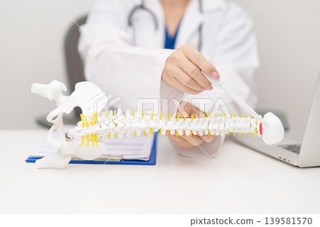 Doctor with human Spine anatomy model. Spinal Cord Disorder and disease, Back pain, Lumbar, Sacral pelvis, Cervical neck, Thoracic, Coccyx, Orthopedist, chiropractic, Office Syndrome and health Doctor with human Spine anatomy model. Spinal Cord Disorder and disease, Back pain, Lumbar, Sacral pelvis, Cervical neck, Thoracic, Coccyx, Orthopedist, chiropractic, Office Syndrome and health 139581570