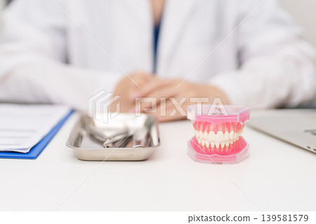 Dentist with tooth Anatomy model. Oral Teeth and disease, Scrape off tartar. March Oral health, Dentist Day, False Teeth. Toothache and Children Dental Health Month and Orthodontic Health Day Dentist with tooth Anatomy model. Oral Teeth and disease, Scrape off tartar. March Oral health, Dentist Day, False Teeth. Toothache and Children Dental Health Month and Orthodontic Health Day 139581579