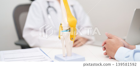 Doctor with Human Knee joint anatomy model. Osteoarthritis, Patellofemoral Pain Syndrome, Patellar Tendinitis, ACL, Anterior Cruciate Ligament, PCL, Posterior, MCL, Medial Collateral, LCL and Lateral 139581592