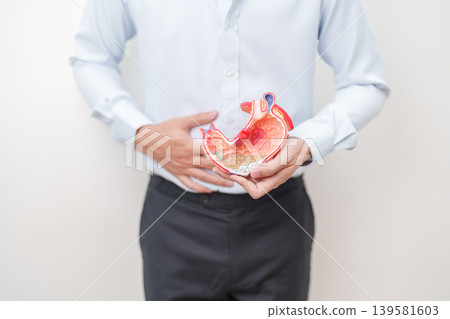 Man having abdomen pain or Stomachache with Gastric anatomy model. stomach diseases and ulcers, Gastroesophageal Reflux, November stomach cancer, Gastroenterologist consultation and Acid reflux Man having abdomen pain or Stomachache with Gastric anatomy model. stomach diseases and ulcers, Gastroesophageal Reflux, November stomach cancer, Gastroenterologist consultation and Acid reflux 139581603