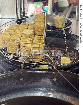 在台灣夜市拍攝攤販熟練的炸臭豆腐 139581791