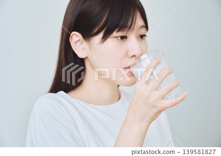 喝一杯水的年輕女人 喝一杯水的年輕女人 139581827