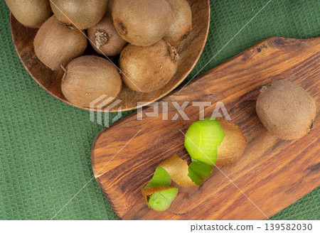 Kiwi fruit peel on wood cutting board Kiwi fruit peel on wood cutting board 139582030
