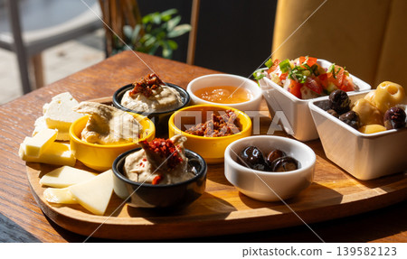 Breakfast appetizer snacks including cheese, hummus, pickled olives 139582123