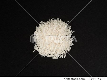 Grated coconut powder. Dry coco flakes pile, shredded desiccated coconut, tropical fruit chips Grated coconut powder. Dry coco flakes pile, shredded desiccated coconut, tropical fruit chips 139582313