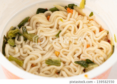Dry instant noodles in cup isolated. Raw spaghetti in a plastic cup, fast food pasta in container Dry instant noodles in cup isolated. Raw spaghetti in a plastic cup, fast food pasta in container 139582550