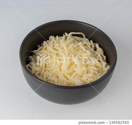 Grated mozzarella cheese. Shredded mozarella texture Grated mozzarella cheese. Shredded mozarella texture 139582593