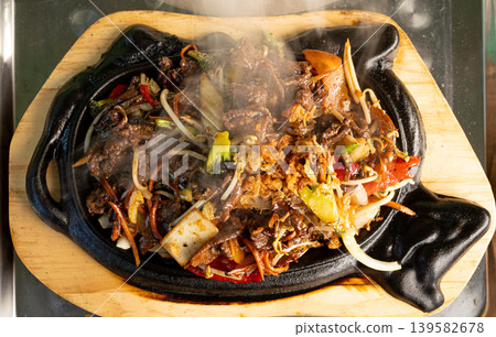 Sizzling beef fajita platter, asian beef stir fry in skillet closeup Sizzling beef fajita platter, asian beef stir fry in skillet closeup 139582678