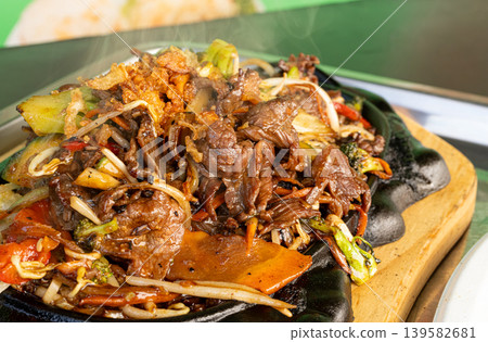 Sizzling beef fajita platter, asian beef stir fry in skillet closeup Sizzling beef fajita platter, asian beef stir fry in skillet closeup 139582681