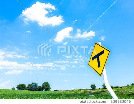 A refreshing blue sky and a T-junction sign in Biei, Hokkaido, during the summer. A refreshing blue sky and a T-junction sign in Biei, Hokkaido, during the summer. 139583046