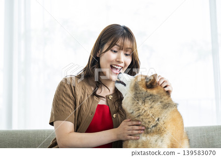 一位年輕女子正在撫摸一隻柴犬。 139583070
