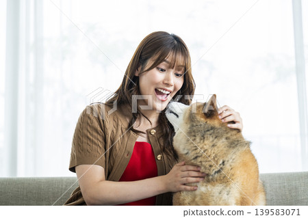 一位年輕女子正在撫摸一隻柴犬。 139583071