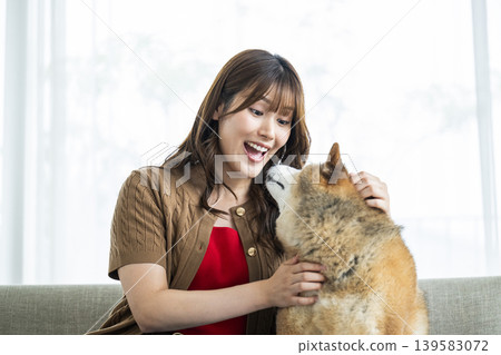 一位年輕女子正在撫摸一隻柴犬。 139583072
