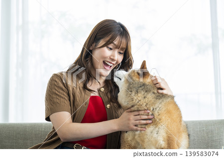 一位年輕女子正在撫摸一隻柴犬。 139583074