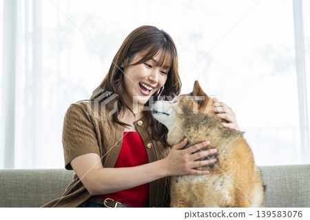 一位年輕女子正在撫摸一隻柴犬。 一位年輕女子正在撫摸一隻柴犬。 139583076