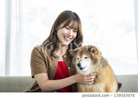 一位年輕女子正在撫摸一隻柴犬。 139583078