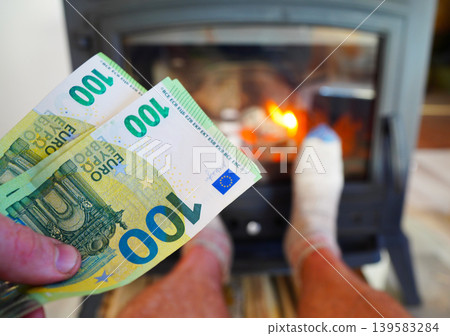 Heating payment. Save money wood stove. Euro money banknotes for payment of heating firewood Heating payment. Save money wood stove. Euro money banknotes for payment of heating firewood 139583284
