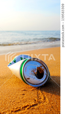 Crumpled beer can on sand beach at sea. Discarded broken can at seashore. Environmental pollution Crumpled beer can on sand beach at sea. Discarded broken can at seashore. Environmental pollution 139583309