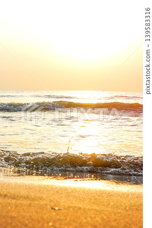 Tranquil seascape on sunset background. Soft sandy shore with warm. Waves at shoreline Tranquil seascape on sunset background. Soft sandy shore with warm. Waves at shoreline 139583316
