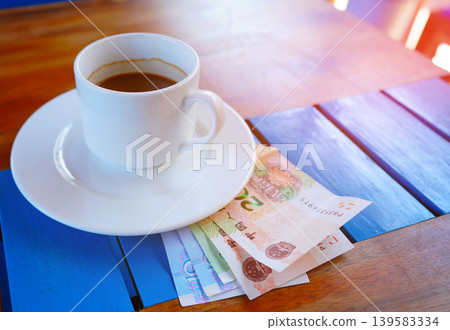 Coffee cup on table with yuan bill money cafe. Payment coffee drink on breakfast. Yuan biill money  139583334