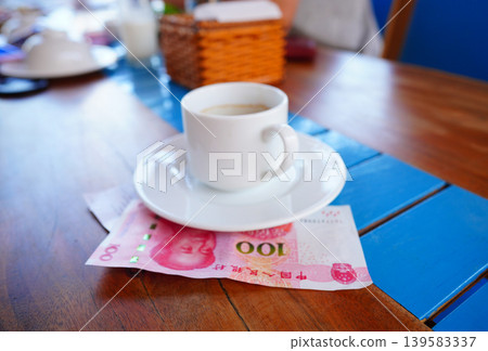 Coffee cup on table with yuan bill money cafe. Payment coffee drink on breakfast. Yuan biill money Coffee cup on table with yuan bill money cafe. Payment coffee drink on breakfast. Yuan biill money 139583337