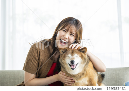 一隻柴犬和一位年輕女子正看著鏡頭。 139583481
