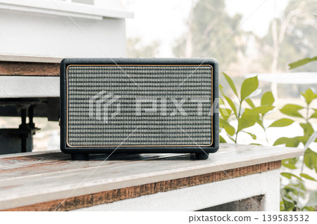 Vintage Bluetooth Speaker on Wooden Stairs in Garden with Morning Sunlight Lifestyle Concept 139583532