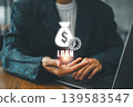 Businessman in suit holding digital loan icon with dollar sign and clock, representing financial services and time management. 139583547